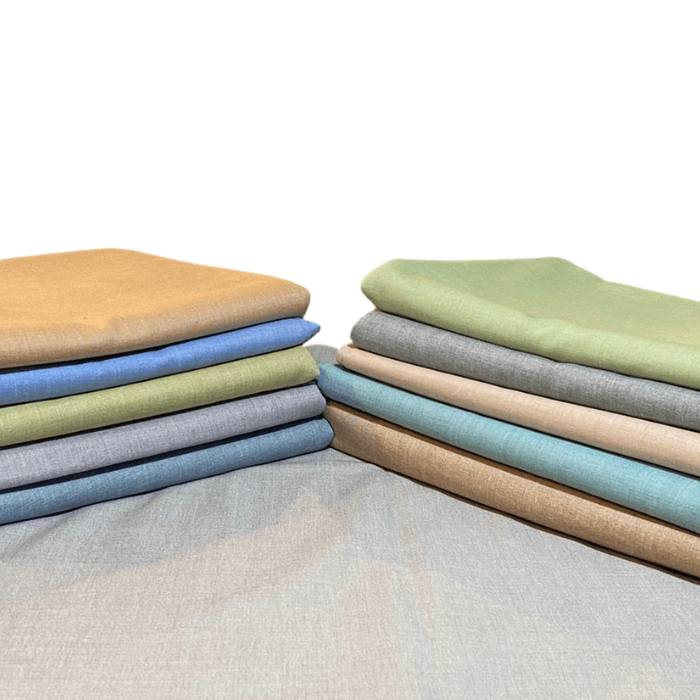 Stacks of Zelburry P.A textured linen-look men's suiting fabrics in ochre, blue, olive, sage, teal and grey